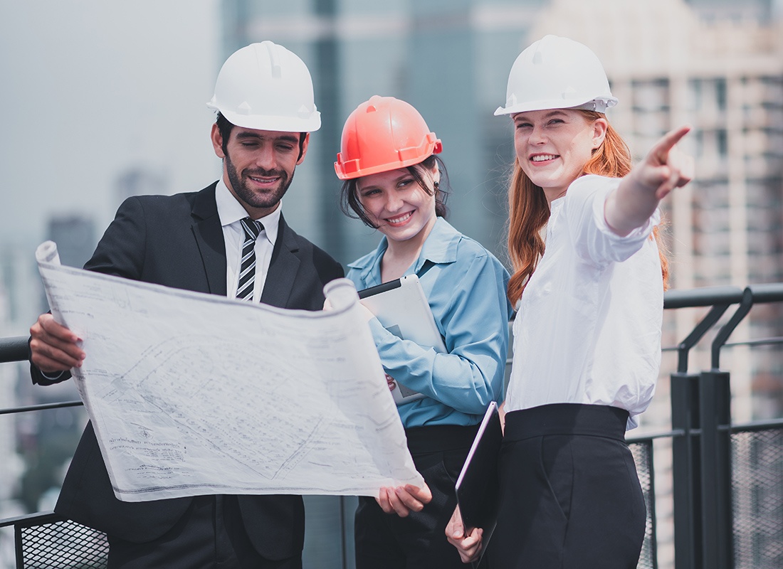 Insurance by Industry - Three Construction Planners Review Documents on a Site