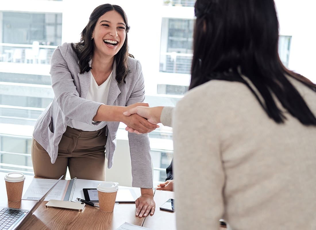 Trusted Professional and Business Partners - Two Business Women Shaking Hands at a Meeting