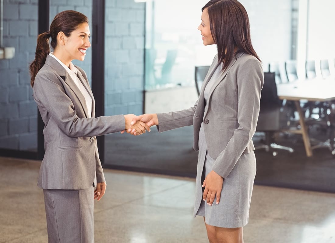 Join Our Team - Two Business Women Shaking Hands in an Office